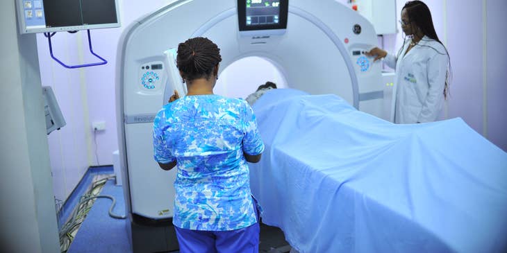 Nuclear medicine technologist operating imaging equipment.