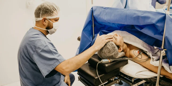 A nurse anesthetist monitoring a patient during surgery.