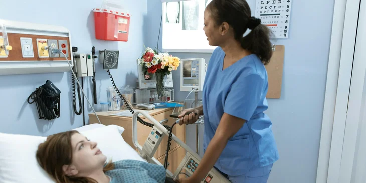 A nurse assistant checking a patient's blood pressure.