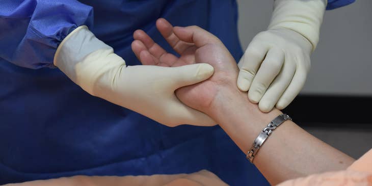 Nurse monitoring patients' pulse rate.