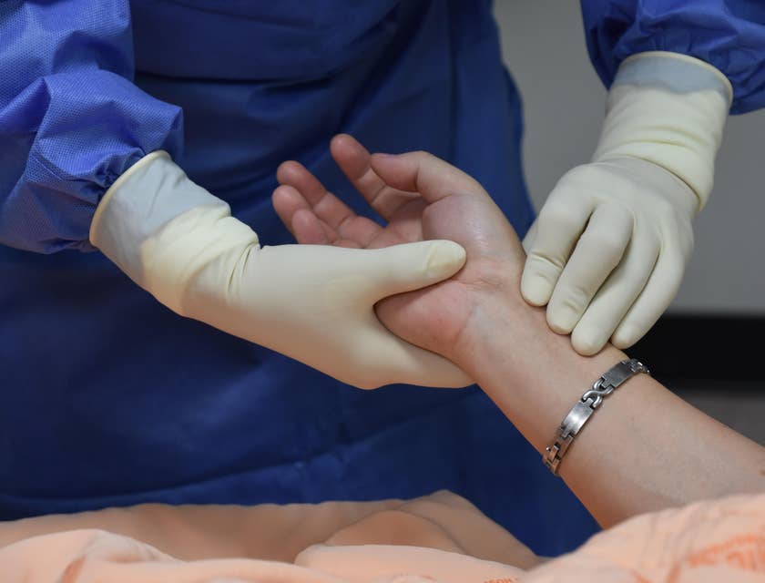 Nurse monitoring patients' pulse rate.