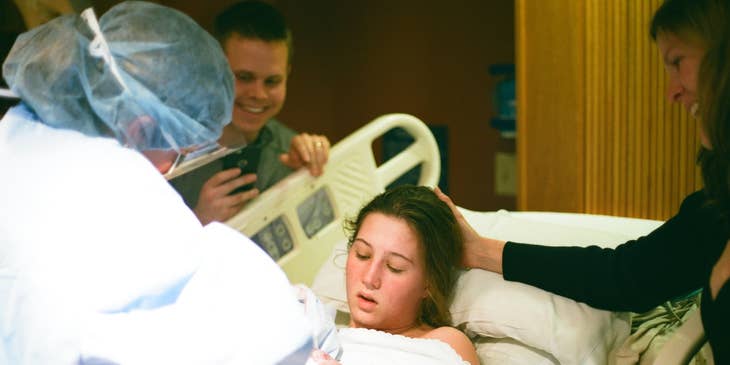 Nurse midwife assists during labor and delivery.