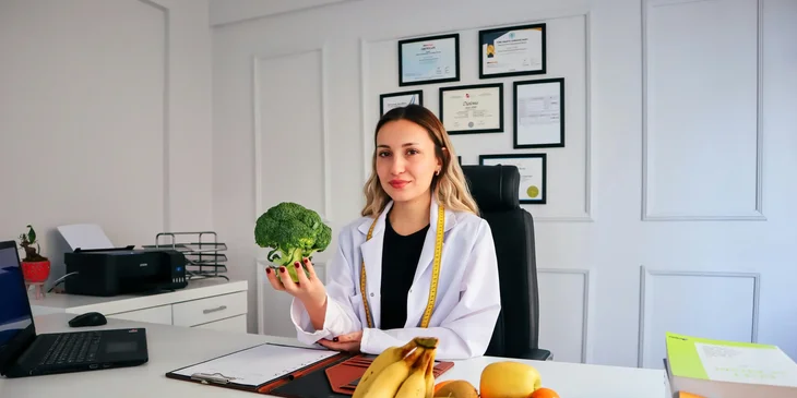 A nutrition educator holding a vegetable.