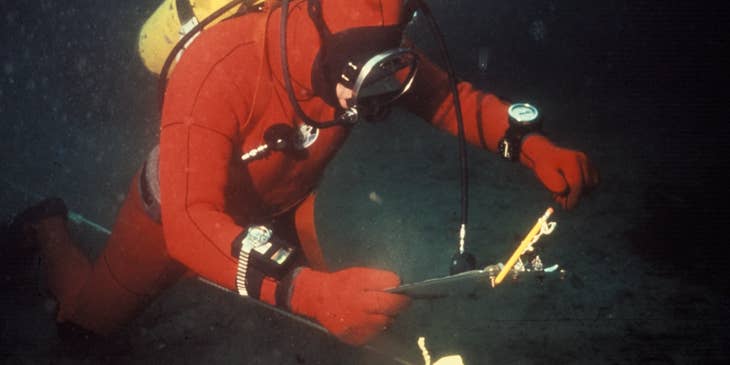 Oceanographer diving in the ocean to setup the equipment for underwater survey