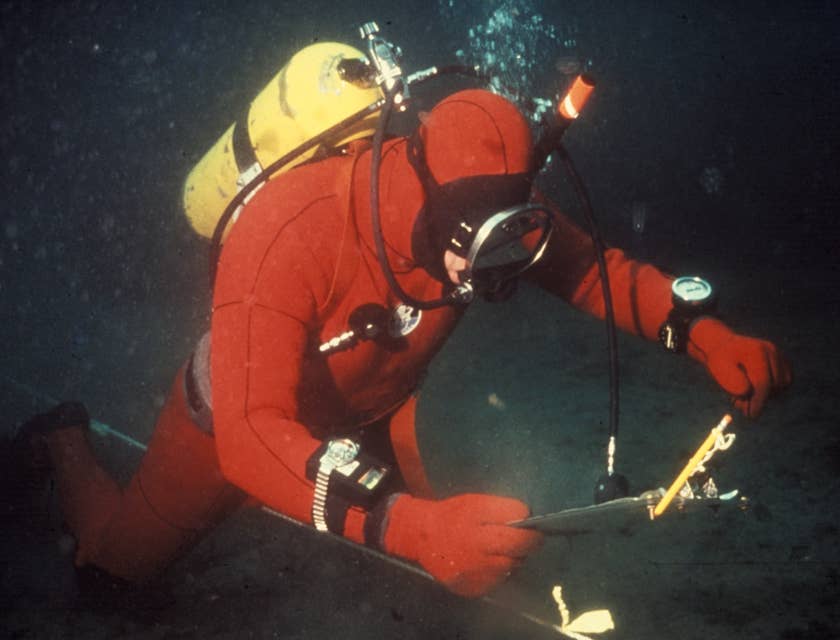 Oceanographer diving in the ocean to setup the equipment for underwater survey