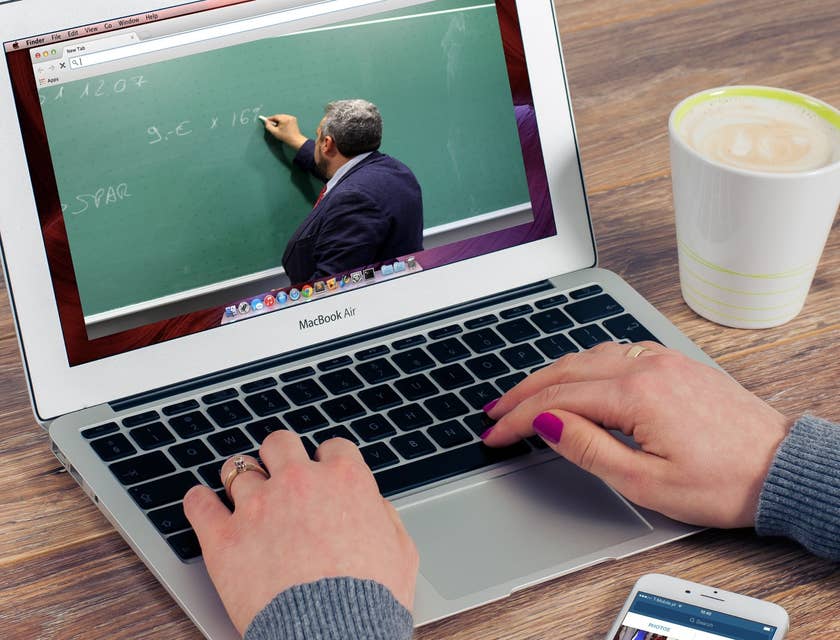 Online teacher writes a new lesson on a chalkboard.