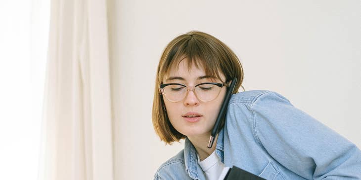 Operations coordinator making a phone call while holding a schedule book