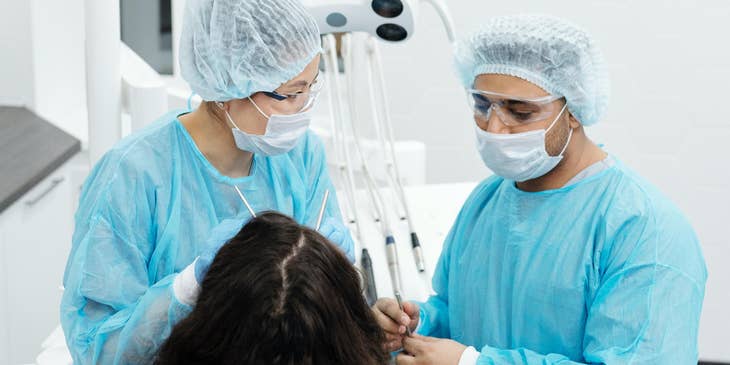 Oral and maxillofacial surgeon removing impacted wisdom teeth..