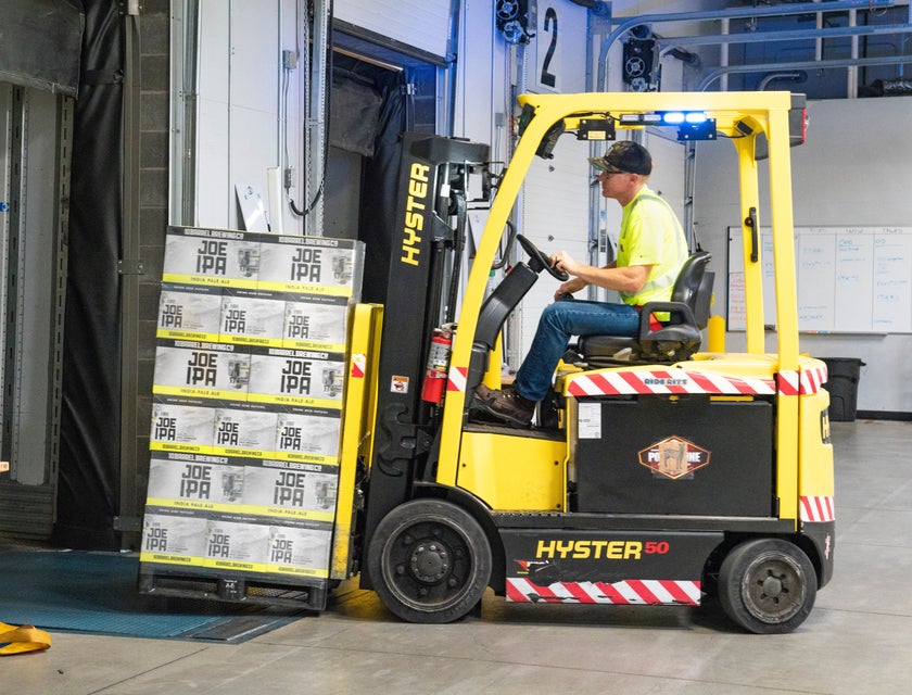 Order selector operating a forklift to transfer the order for shipping