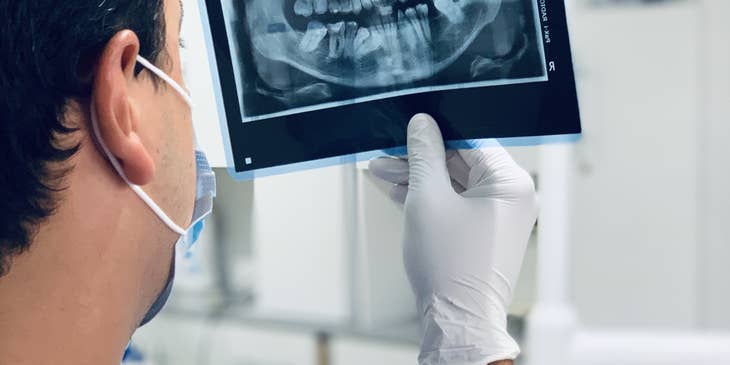 Orthodontist studying dental X-ray of a patient.