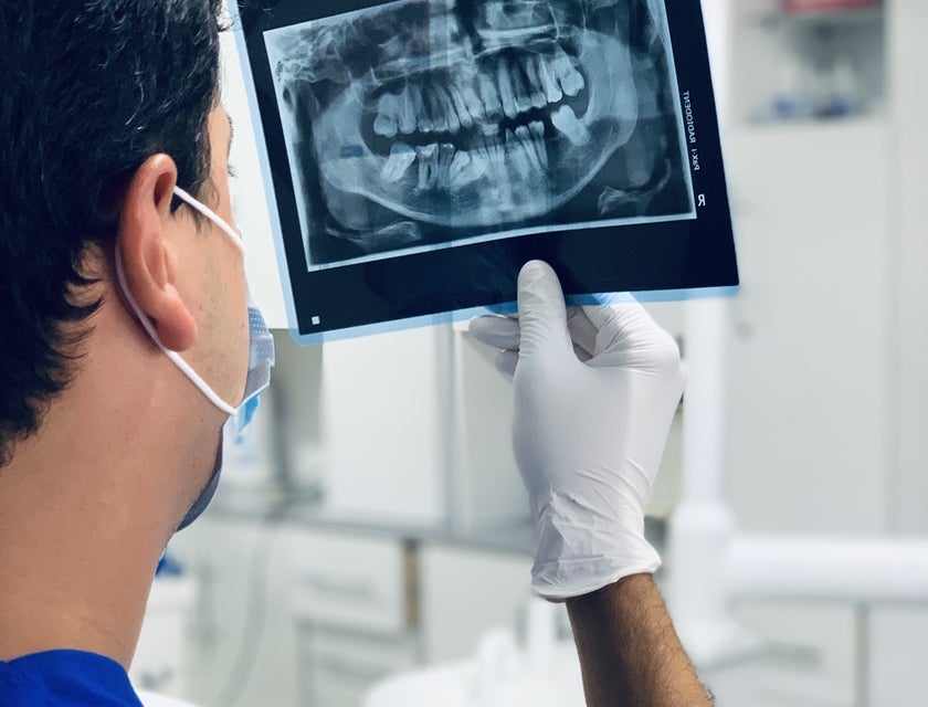 Orthodontist studying dental X-ray of a patient.
