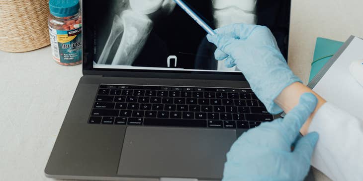 The orthopedic doctor educating the patient on the injury and prescribes a course of treatment.
