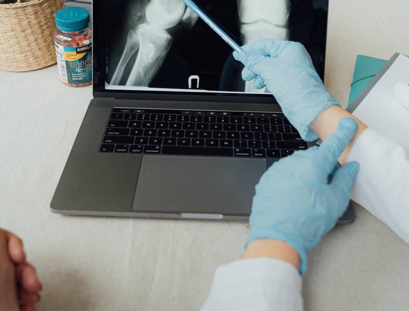 The orthopedic doctor educating the patient on the injury and prescribes a course of treatment.