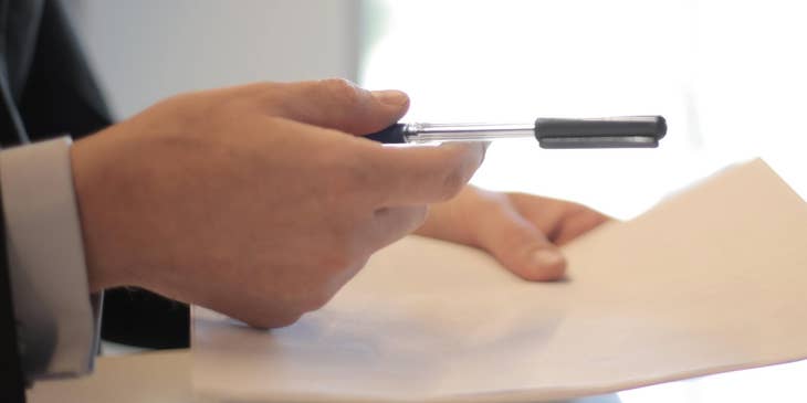 A business man giving a woman a paid time off policy to sign