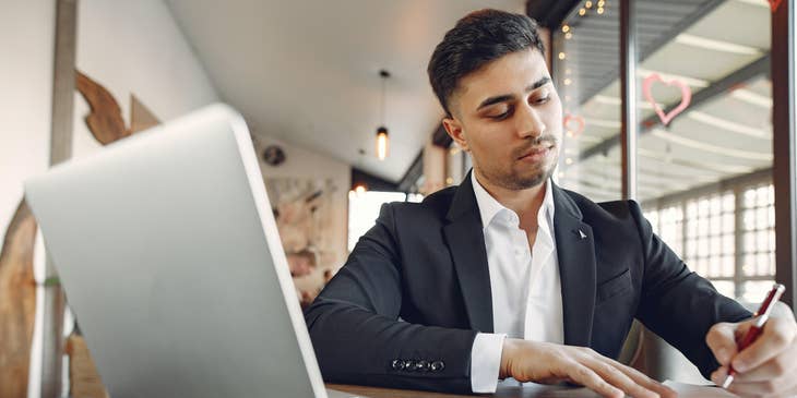 A paralegal working in front of a laptop preparing some legal documents requested by attorney.
