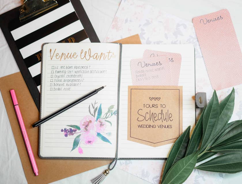 Party planner's notes and checklist with pens and clipboard.