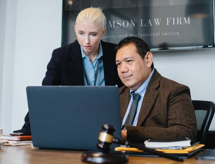 A female patent paralegal reporting and working beside an attorney in a law firm.