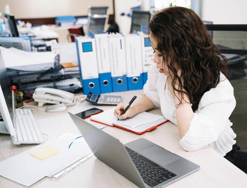 Payroll clerk writes down schedule of meetings regarding payroll concerns.