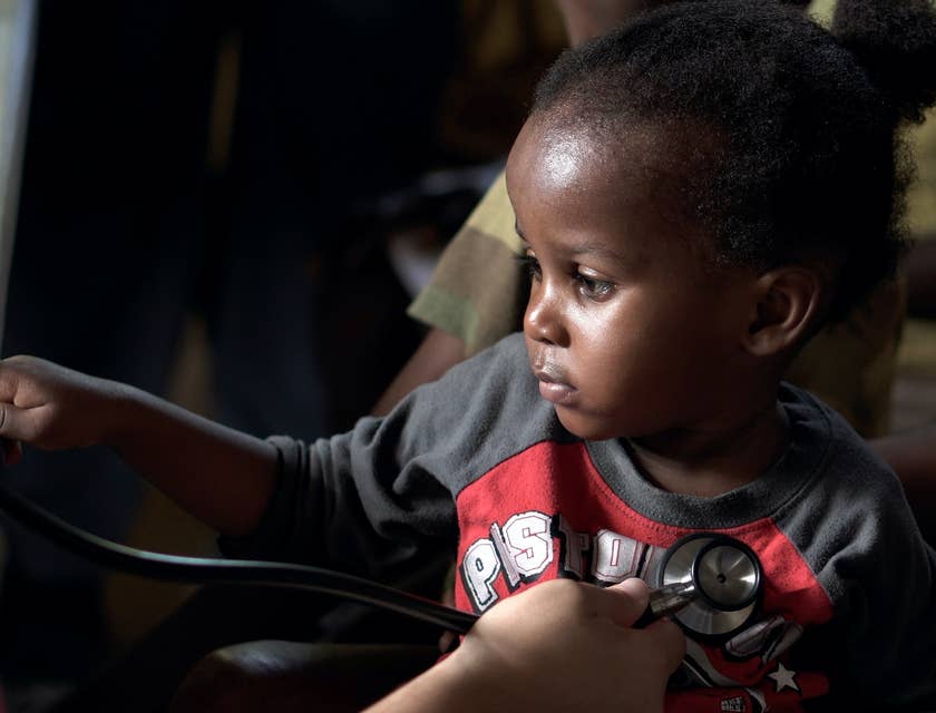 Pediatric cardiologist monitors the baby's heart using a stethoscope.
