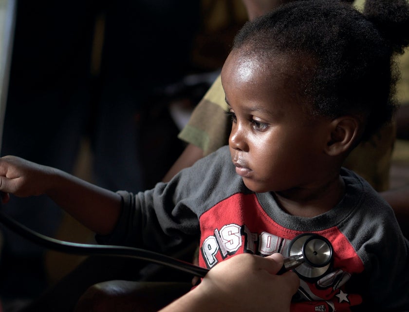 Pediatric cardiologist monitors the baby's heart using a stethoscope.