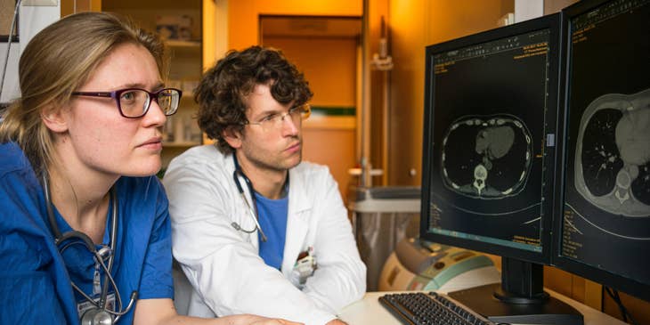 Pediatric oncologist consults with a colleague to analyze MRI results.