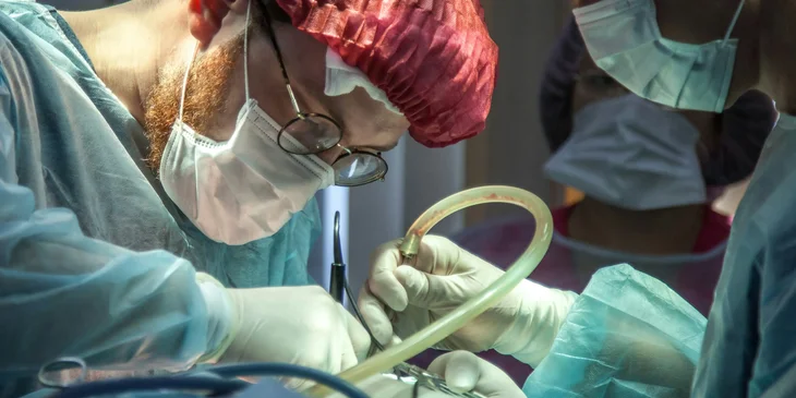 A pediatric surgeon carefully operating on a young patient with his assistant.