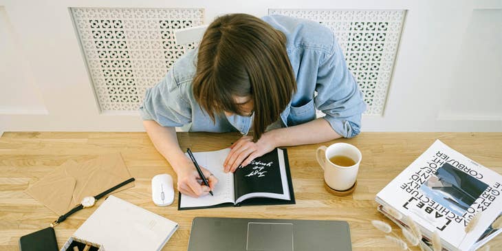 An author writing in her notebook.