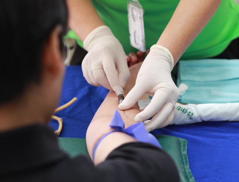 Phlebotomist extracts blood from the patient for diagnostic findings.