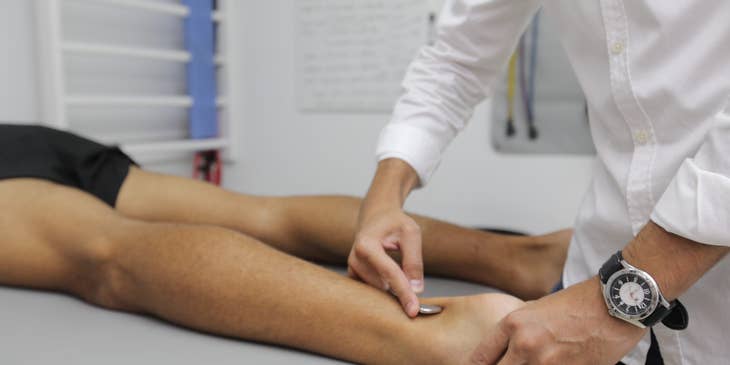A practitioner performing physical therapy on a patient.
