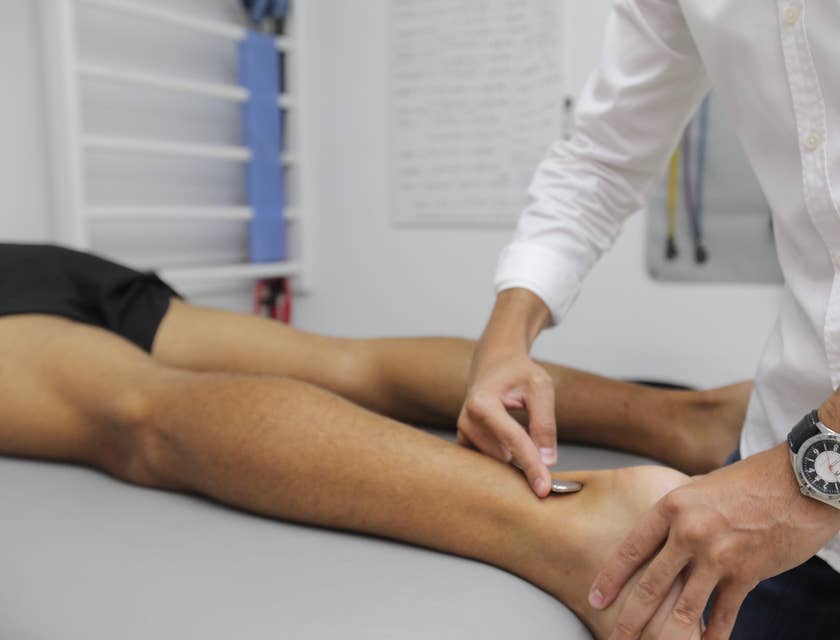 A practitioner performing physical therapy on a patient.