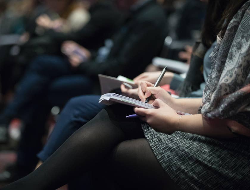 A physician recruiter taking down notes in a conference.