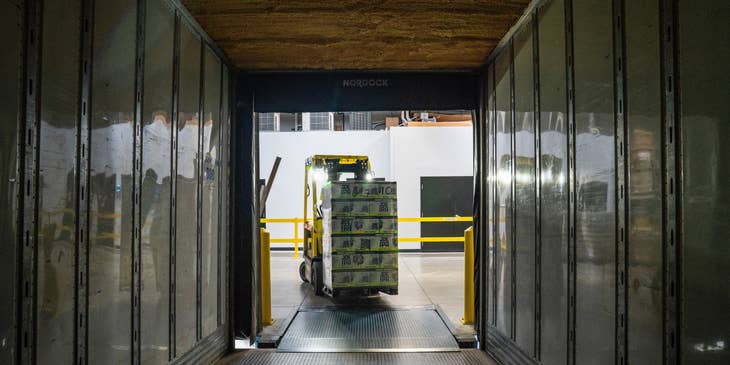 Picker loading the packages into the truck using forklift