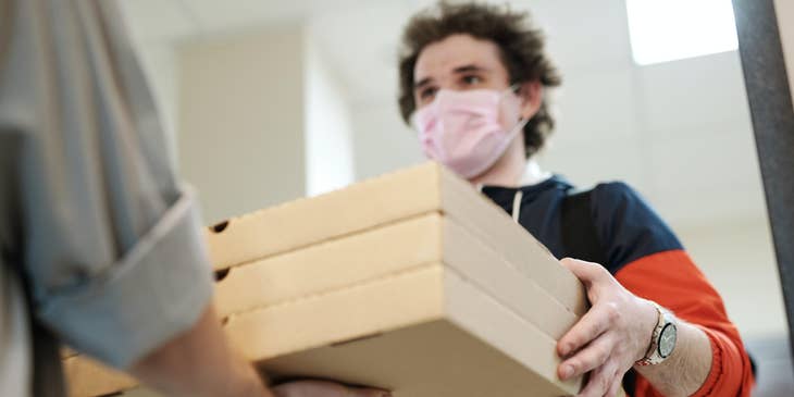 Pizza delivery driver delivering the customers order on the customers preferred location