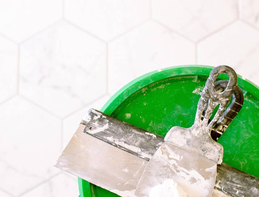 wall plaster on metal scraper and green lid