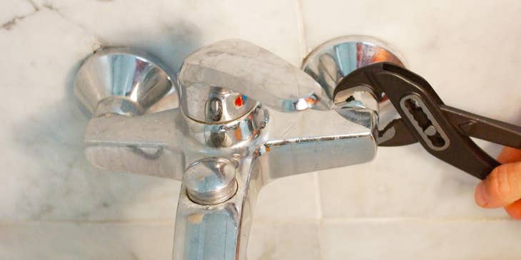 Plumber helper fixing a shower faucet.