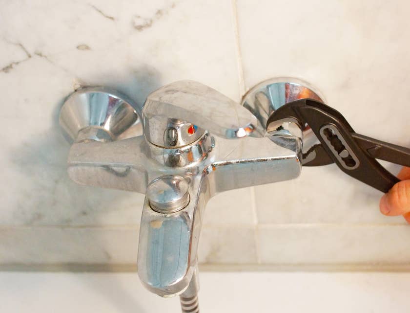 Plumber helper fixing a shower faucet.