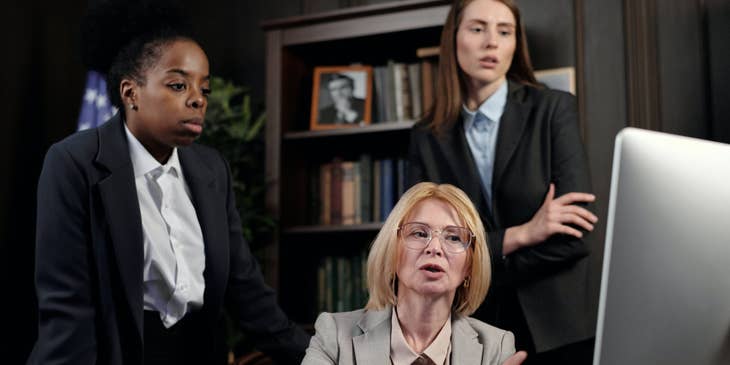Political analyst points to her computer screen while her two assistants look on