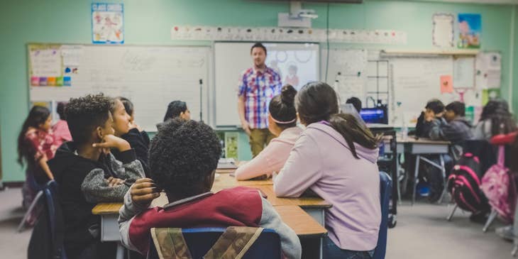 Postsecondary teacher delivers a new lesson to a group of high school students.