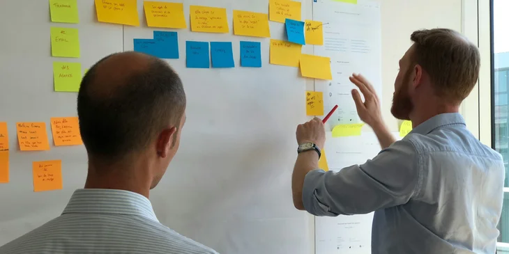 A principal working with a teacher in creating new learning ideas in post-its.