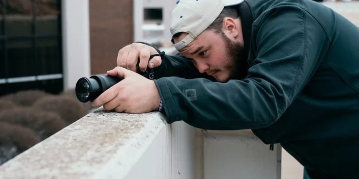A private investigator working undercover doing surveillance and taking photos.