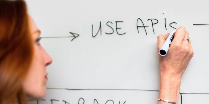 Process engineer writing on the whiteboard updates on the existing process for the new software.