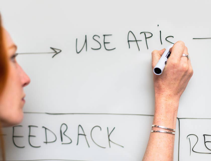 Process engineer writing on the whiteboard updates on the existing process for the new software.
