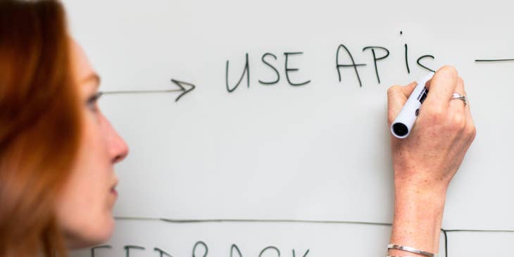 Process engineer writing on the whiteboard updates on the existing process for the new software