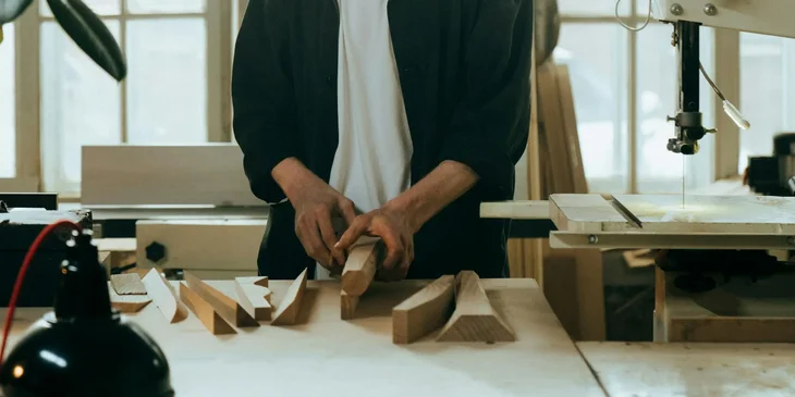 A product designer working on a new project while checking his wood designs.
