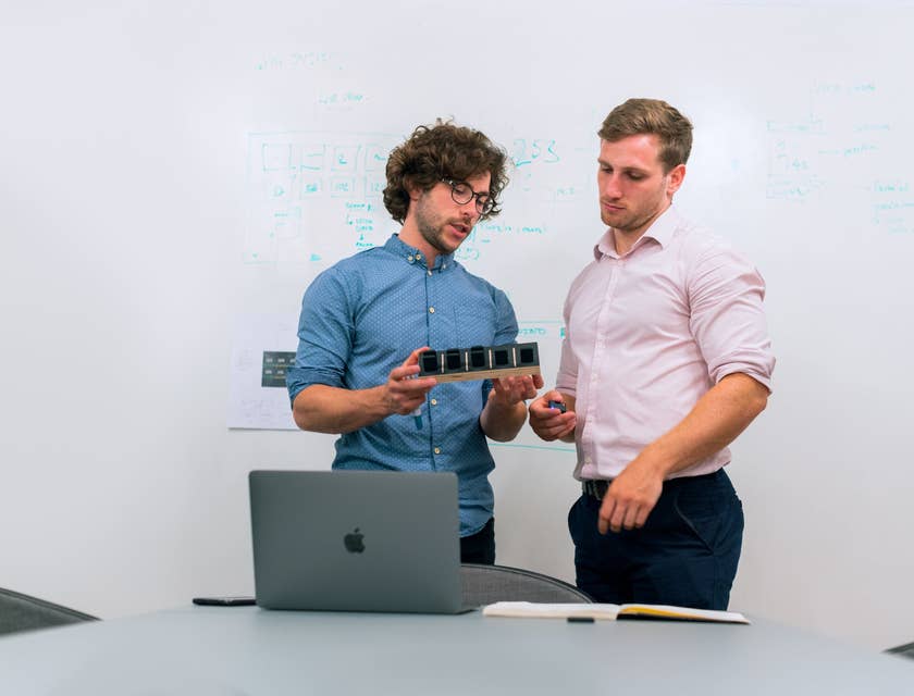 two product development engineers discussing the product at hand while standing by the whiteboard