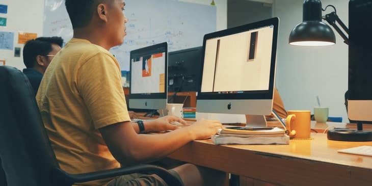 A couple of production artists seriously working on a project from their new client.