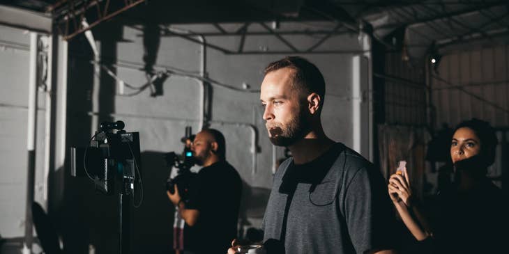 a production coordinator holding his coffee while taking a break from the set