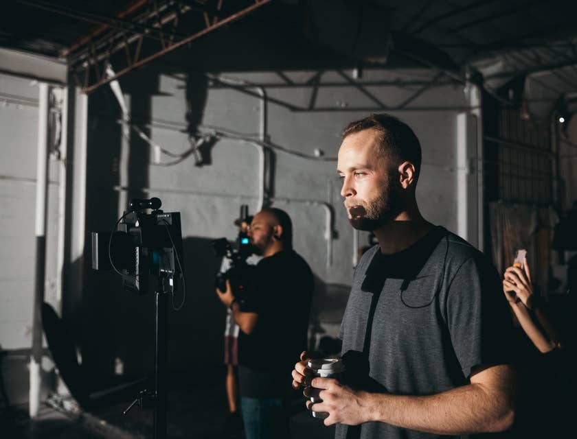 a production coordinator holding his coffee while taking a break from the set