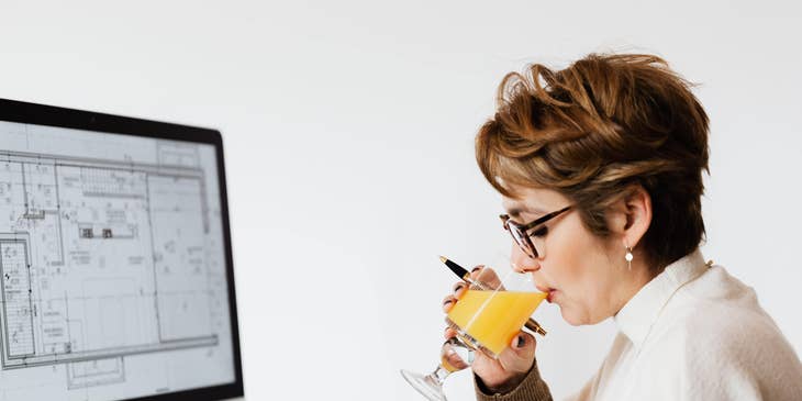 Project architect working on a design project while drinking juice.