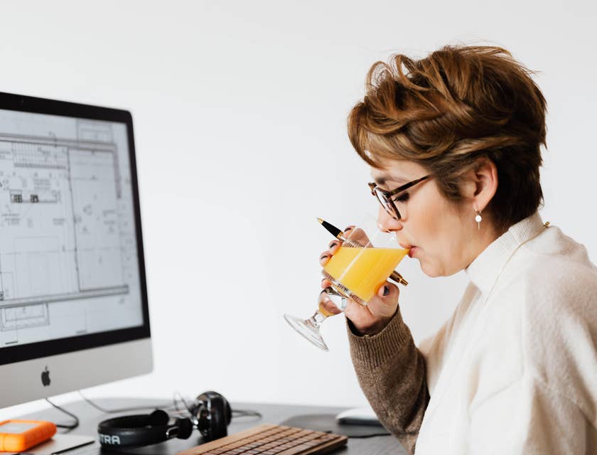 Project architect working on a design project while drinking juice.